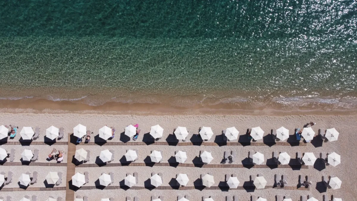 Rijen parasols aan het kiezelstrand van Barbati aan de oostkust van Corfu
