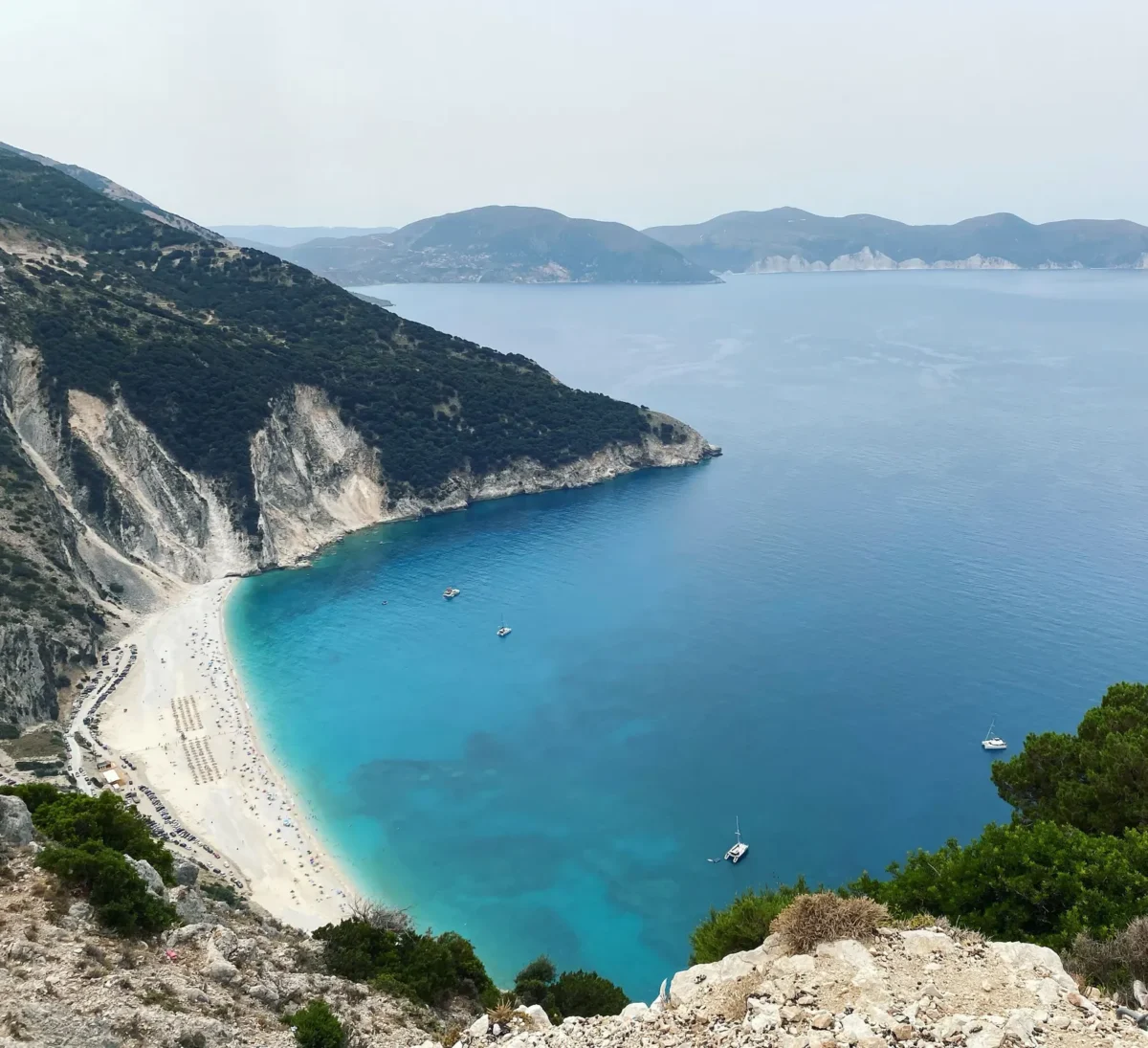 Luchtfoto van het witte strand van Myrtos onder groene kliffen op Kefalonia