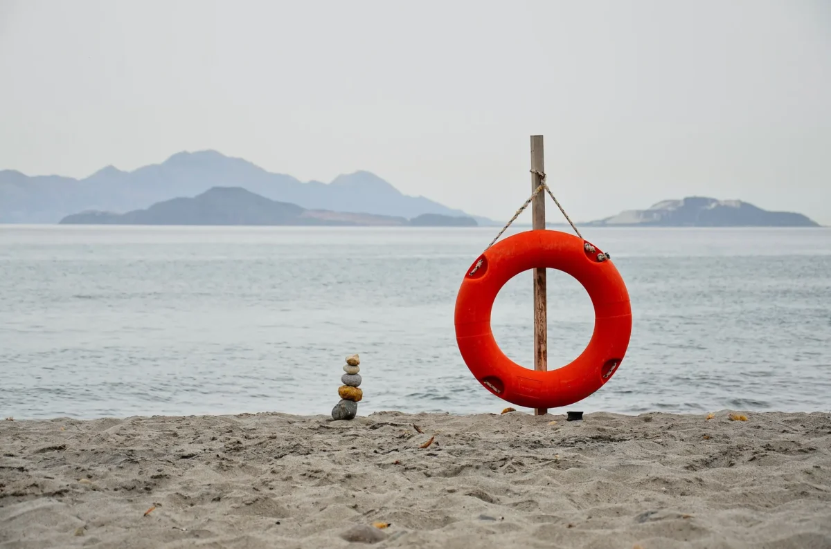 Rustig zandstrand op Kos met een reddingsboei en uitzicht op Kalymnos in zacht najaarslicht
