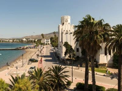 Boulevard van Kos-stad met palmbomen, een historisch gebouw en het stadsstrand