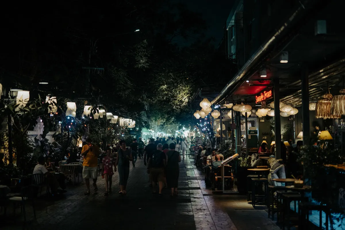 Drukke terrassen met gekleurde lichtjes in een uitgaansstraat op een zomeravond