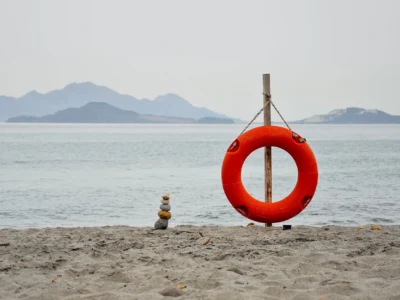 Rustig zandstrand op Kos met een reddingsboei en uitzicht op de buureilanden