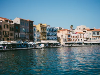 Kleurrijke gevels langs de Venetiaanse haven van Chania op Kreta onder een blauwe lucht