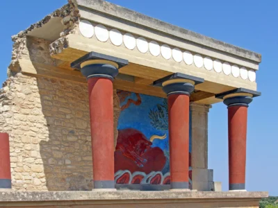 Gereconstrueerde rode zuilen en stierfresco in het Minoïsche paleis van Knossos op Kreta