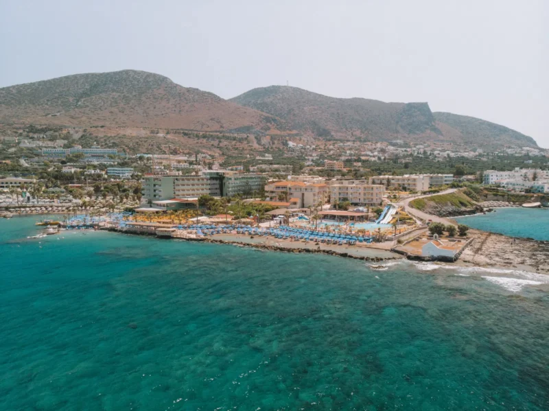 Luchtfoto van de kust bij Hersonissos op Kreta met resorts aan zee en bergen