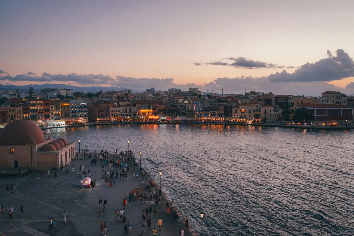 Venetiaanse haven van Chania op Kreta bij zonsondergang met een rustige boulevard