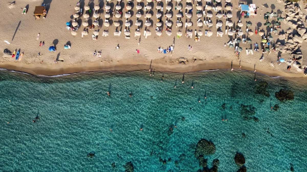 Luchtfoto van een zandstrand met parasols en turquoise water in de regio Chania op Kreta