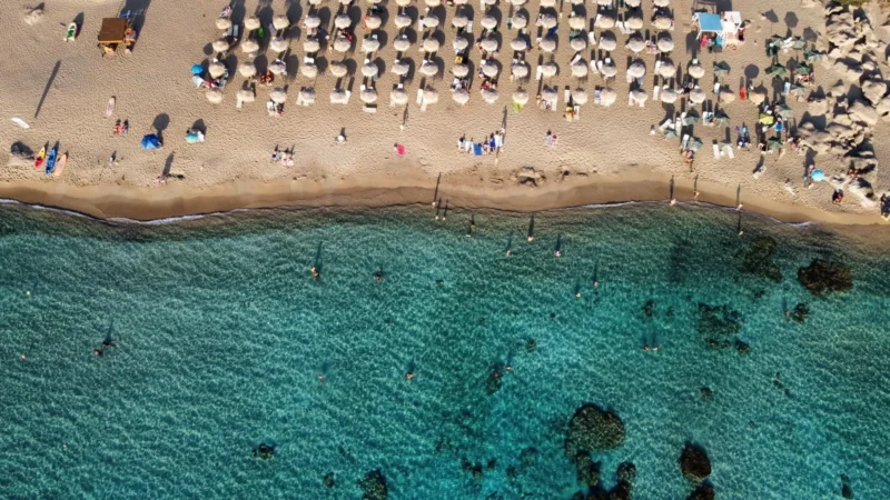 Luchtfoto van een zandstrand met parasols en turquoise water in de regio Chania op Kreta