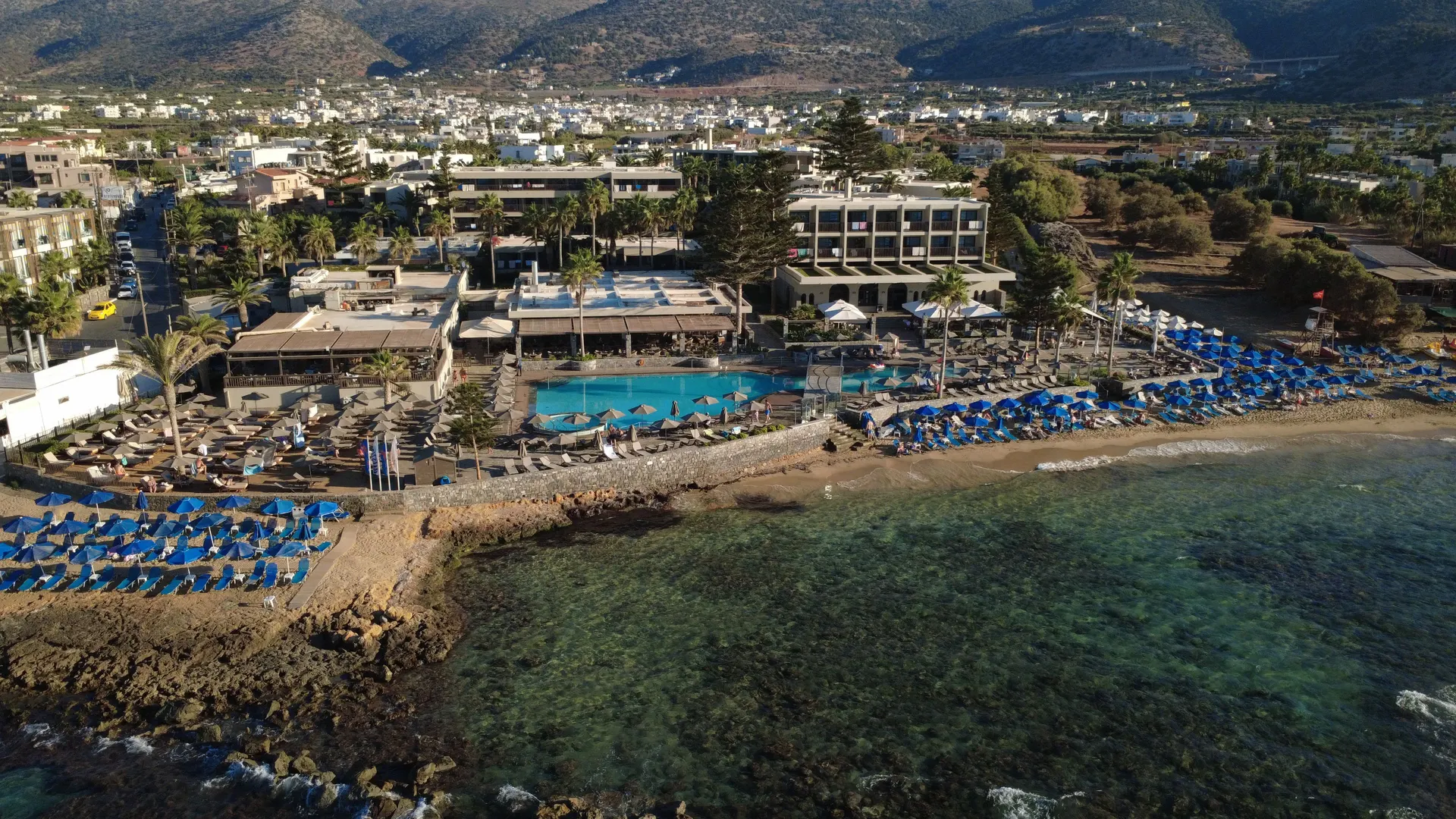 Luchtfoto van een strandresort met zwembaden aan de kust van Malia op Kreta