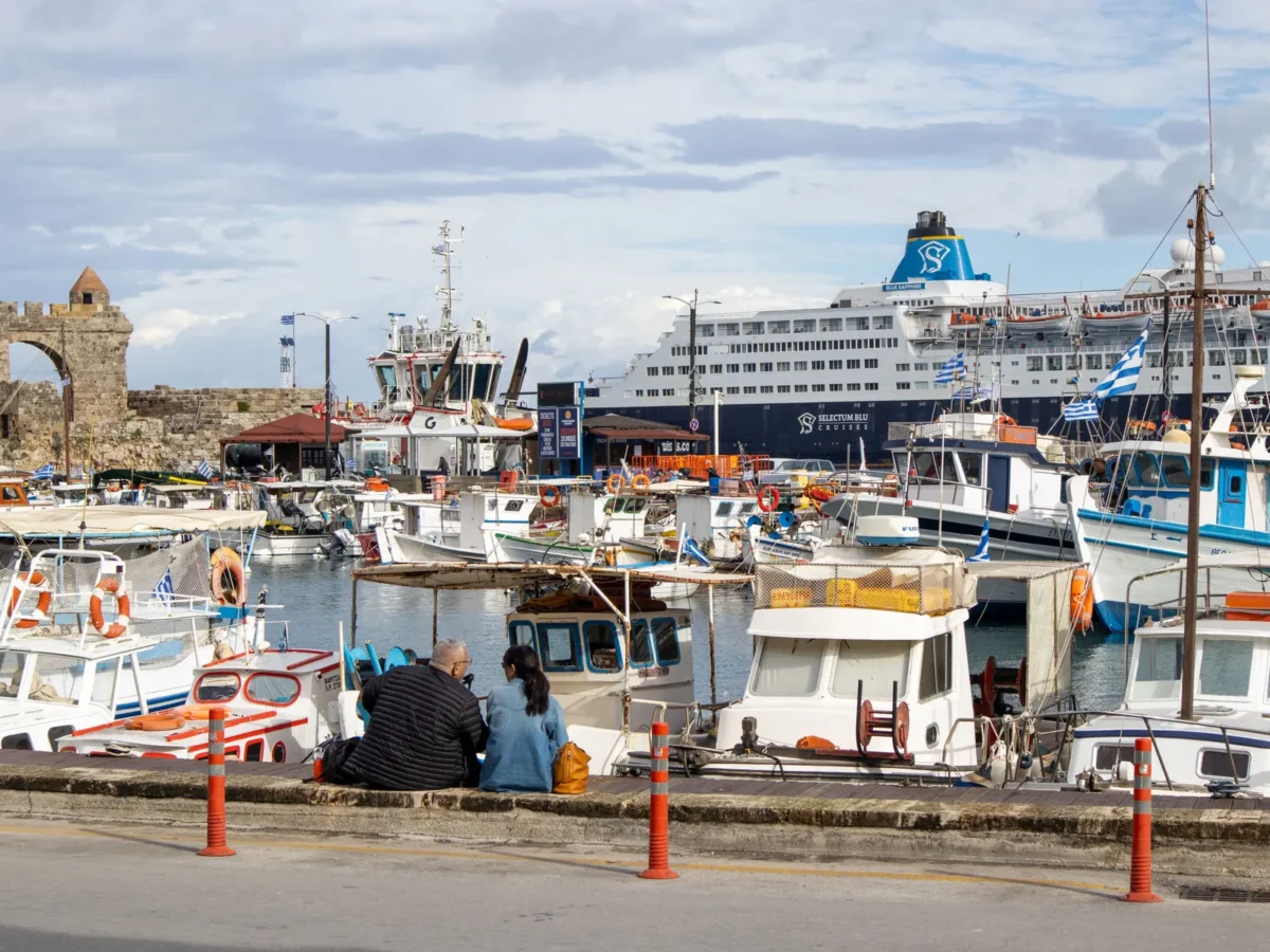 Vissersboten en een cruiseschip in de haven van Rhodos-stad naast de middeleeuwse muur
