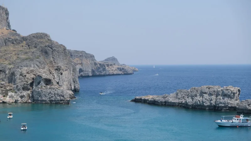 Rotskust met helder blauw water bij Lindos op Rhodos