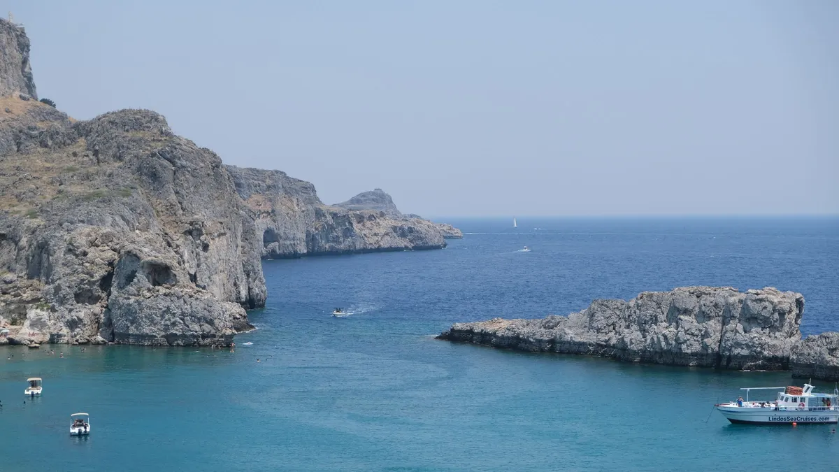 Rotskust bij Lindos op Rhodos met helder water en kleine boten