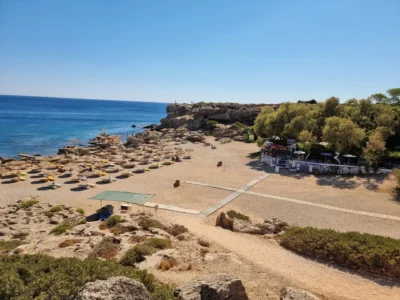 Strand met rieten parasols en strandbedjes op Rhodos op een zonnige zomerdag