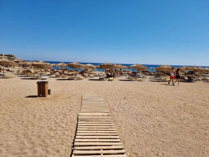 Zandstrand met strandpad en parasols op Rhodos als sfeerbeeld