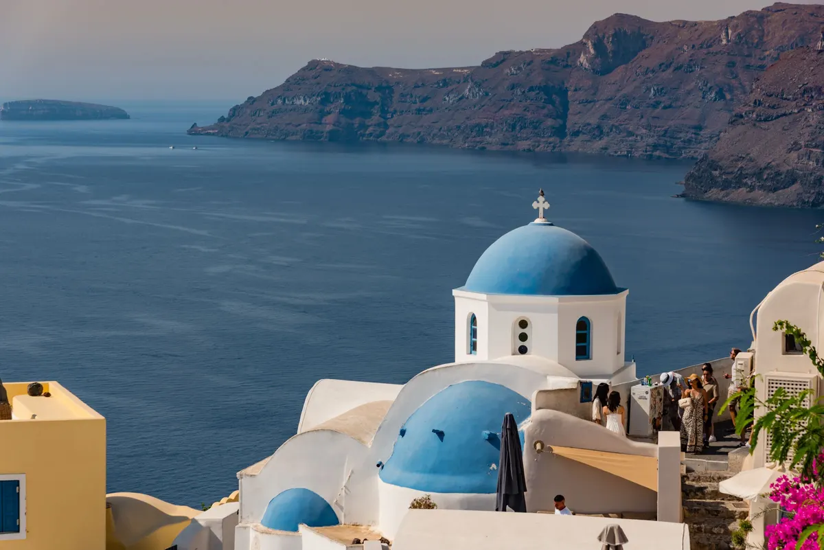 Blauwe kerkkoepels in Fira op Santorini met uitzicht over de caldera en de Egeïsche Zee