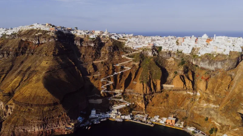 Luchtfoto van Fira op Santorini met witte huizen op de kraterrand en het zigzagpad naar de oude haven