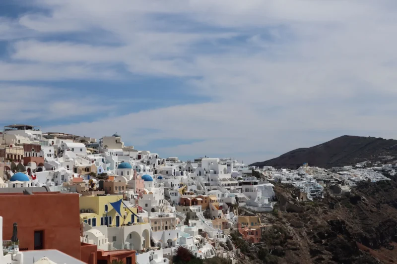 Witte huizen en blauwe koepels van Oia op Santorini boven de Egeïsche Zee