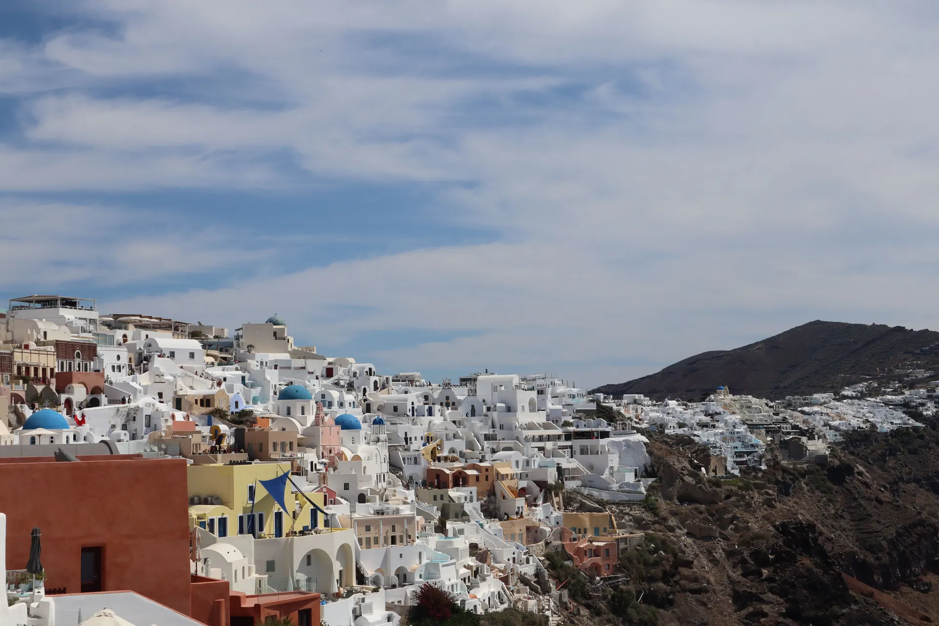 Witte huizen en blauwe koepels van Oia op Santorini boven de Egeïsche Zee