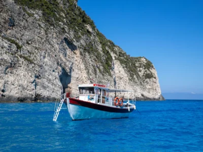 Rondvaartboot bij de witte kliffen van Zakynthos in helderblauw water