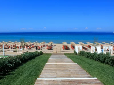 Strand op Zakynthos met rijen parasols en helder blauw water