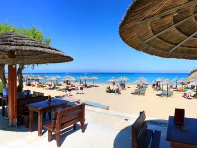 Rieten parasols en een strandbar aan een zandstrand op Zakynthos